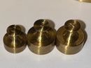 Three brass weights on a white background