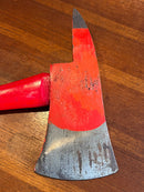 Red axe with a metallic head on a wooden surface
