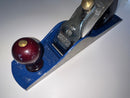 Blue hand plane with a wooden handle on a white background