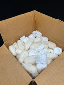 Cardboard box filled with white bubble wrap on a black background