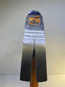 Metal tool with wooden handle on a light gray background